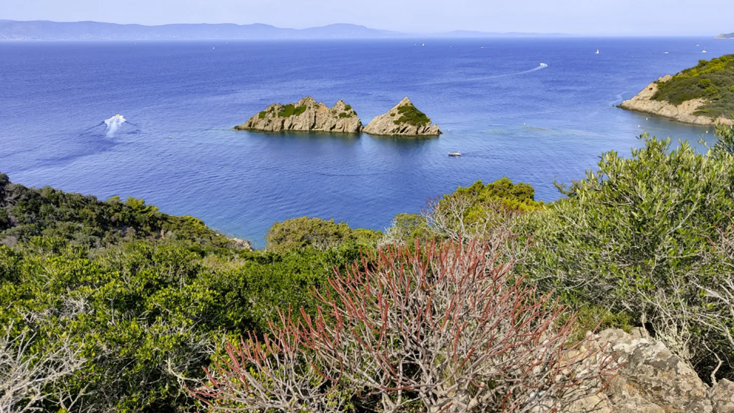 Por-Cros : vue sur la mer bleu et calme avec au loin la côte et en deuxième plan deux ilots rocheux.
