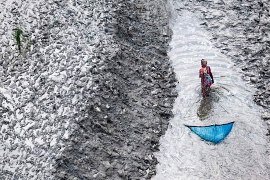 ©Yann Arthus-Bertrand - Femme pêchant au filet sur un bras du delta, sud de Padmapukur, district Khulna, Bangladesh (22° 15’ 58,86” N – 89° 11’ 42,63” E)